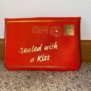 Brand: IPSY. Color: Red and gold.